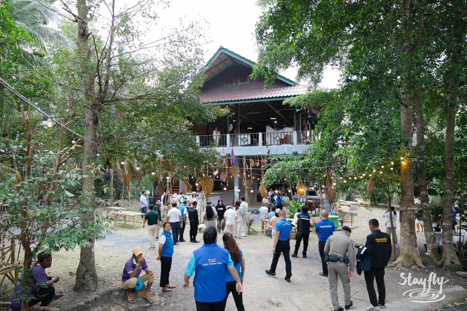 Crowd including uniformed staff outside main venue building.