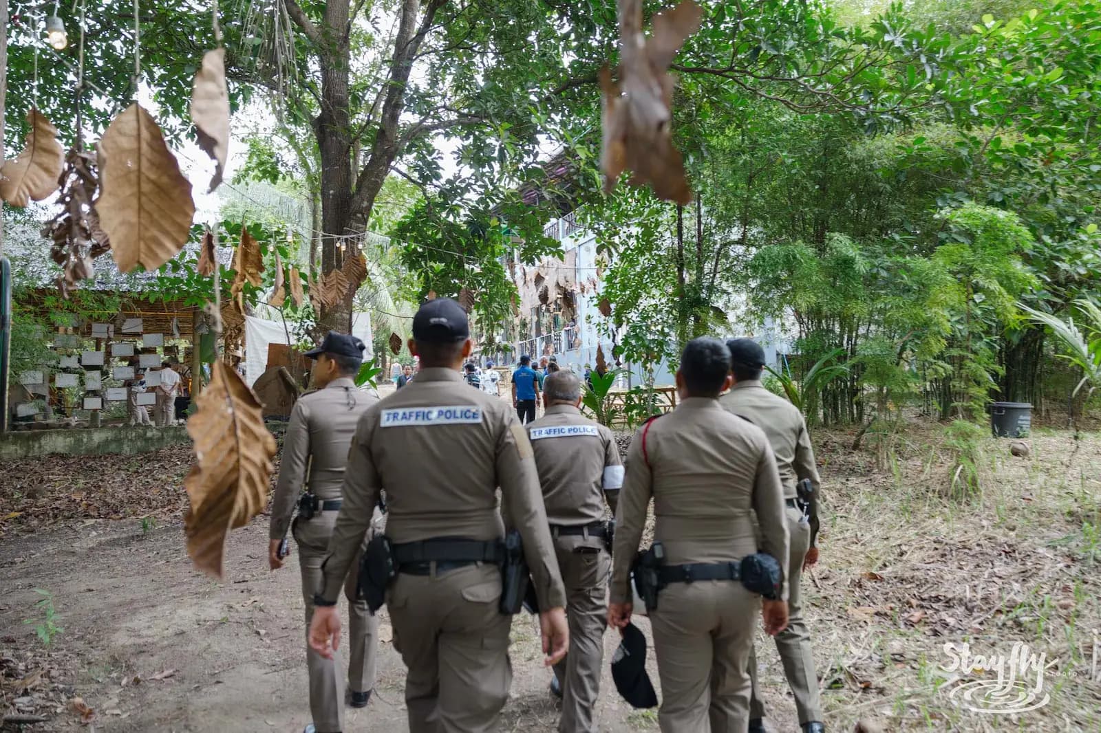 Police officers walking away down forest path.