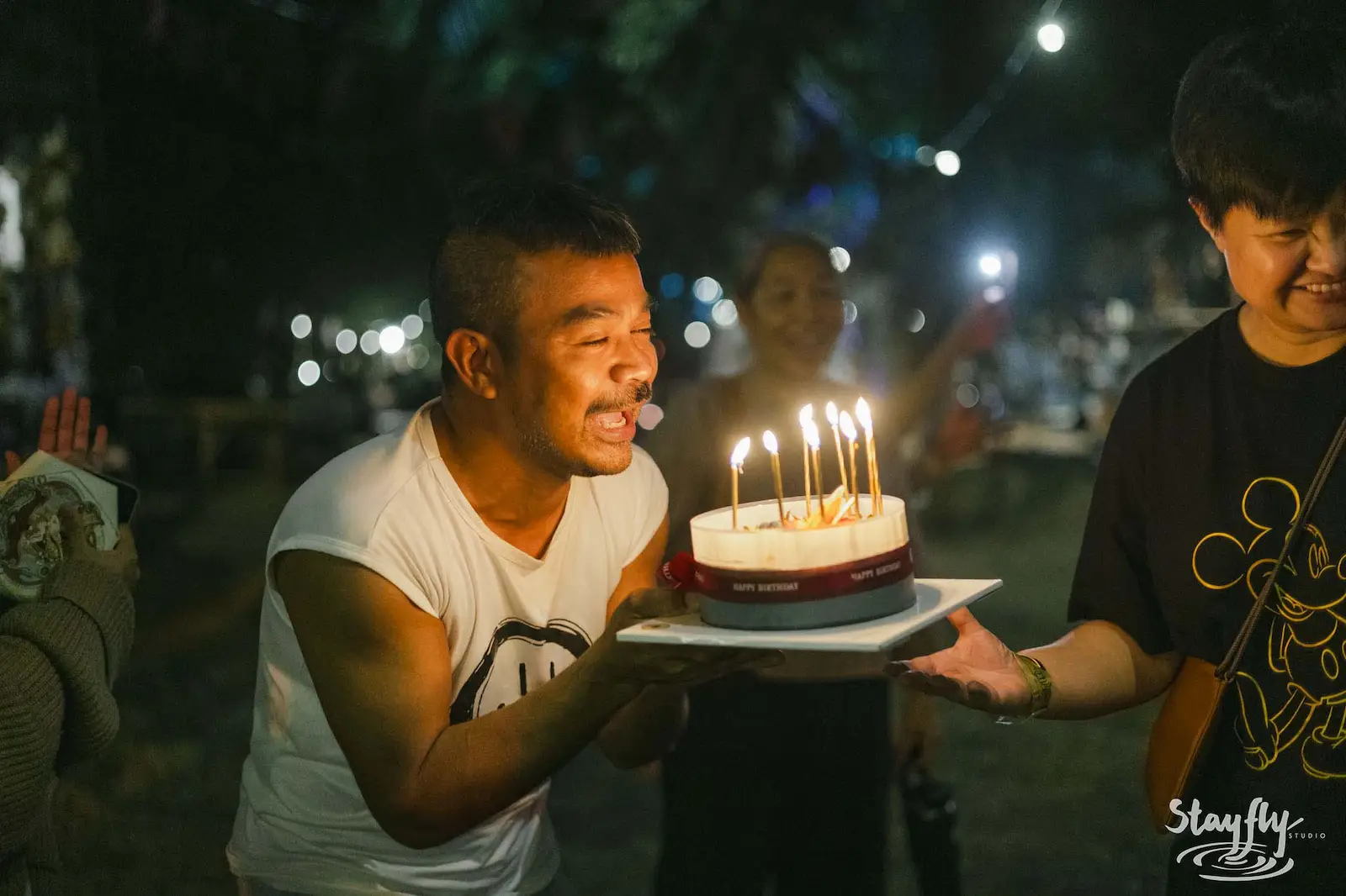 Man blowing out candles on birthday cake.