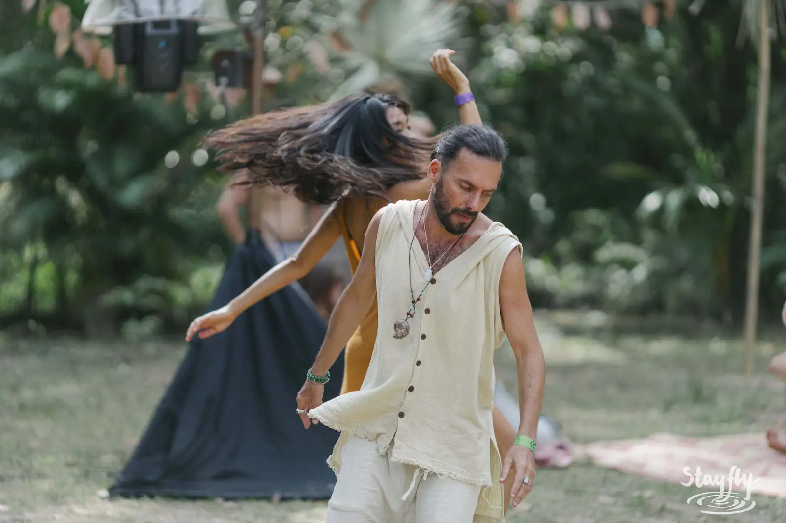 Man and woman dancing together in daylight garden.