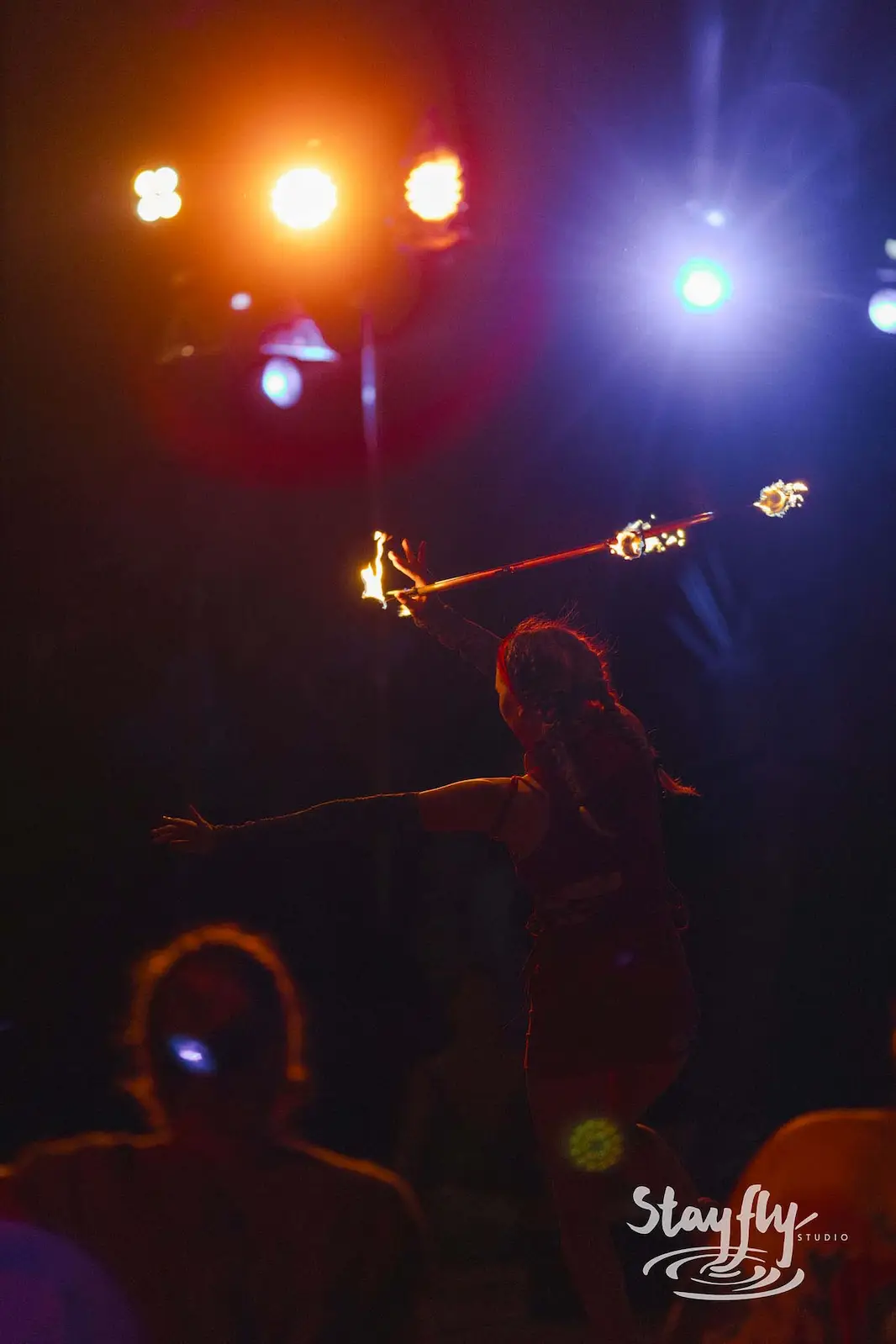 A fire performer traces bright arcs of flame through the dark.