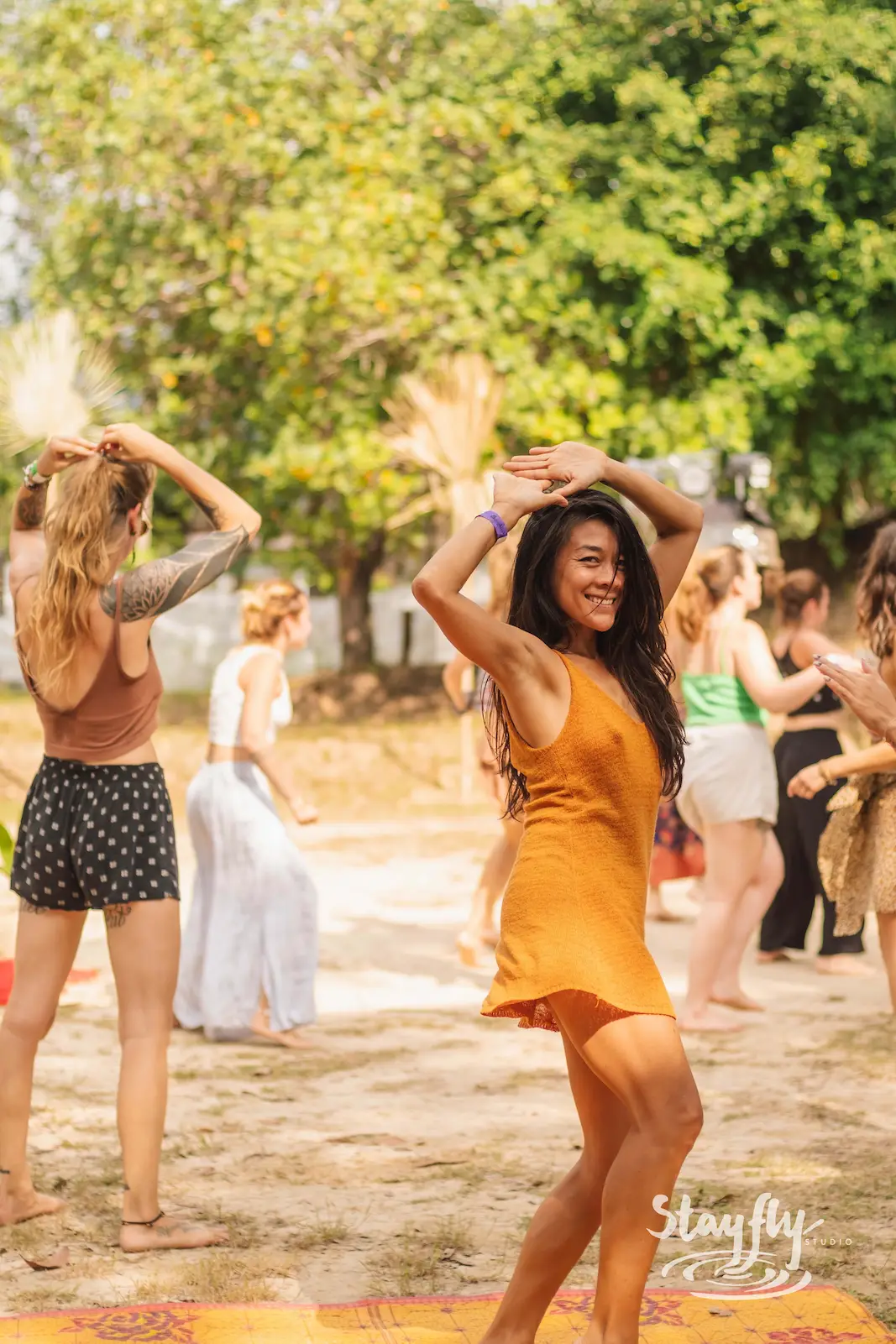 Woman dancing among a group during the day.