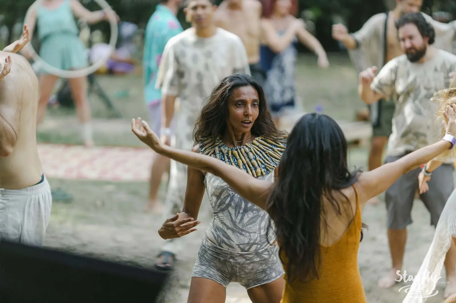 Group dancing outdoors, body paint visible.