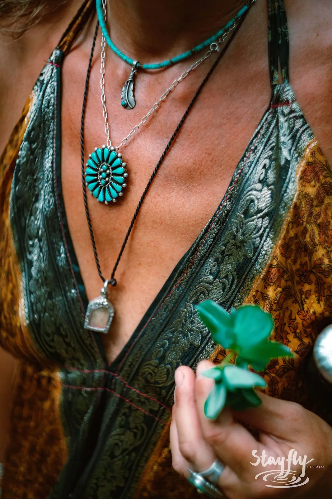 Close-up of turquoise necklaces on woman's chest.