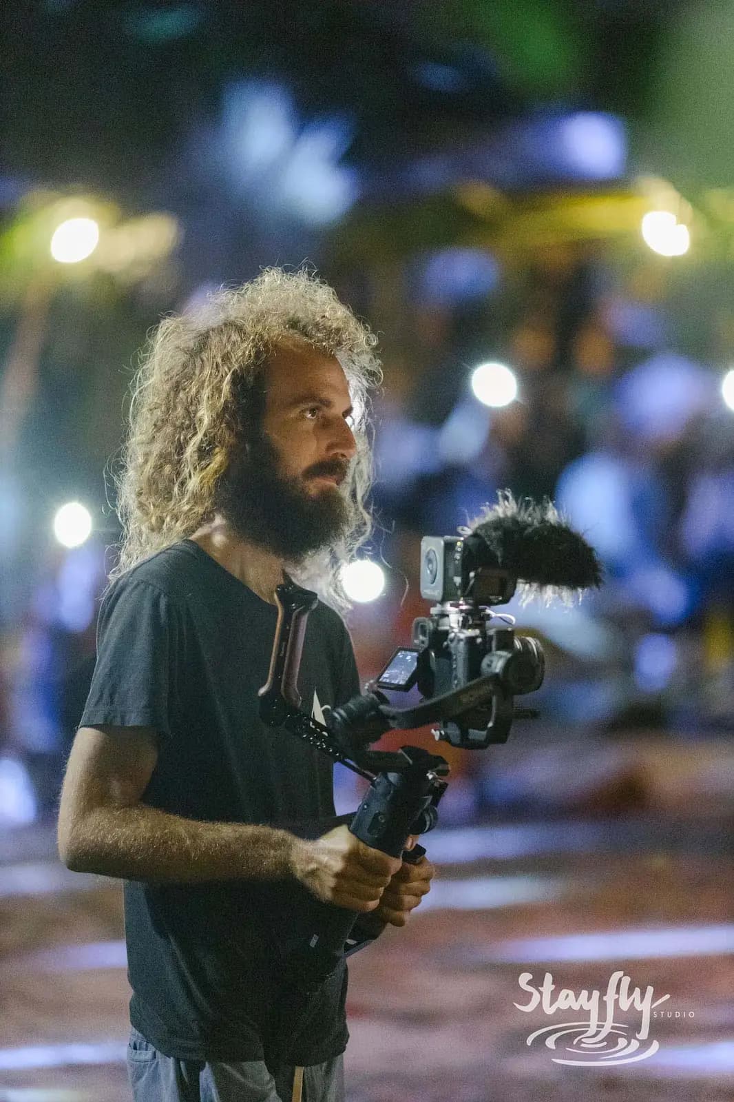 Videographer with camera rig filming at night.