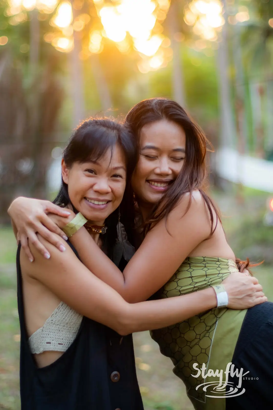 Two women embracing in golden-hour light.