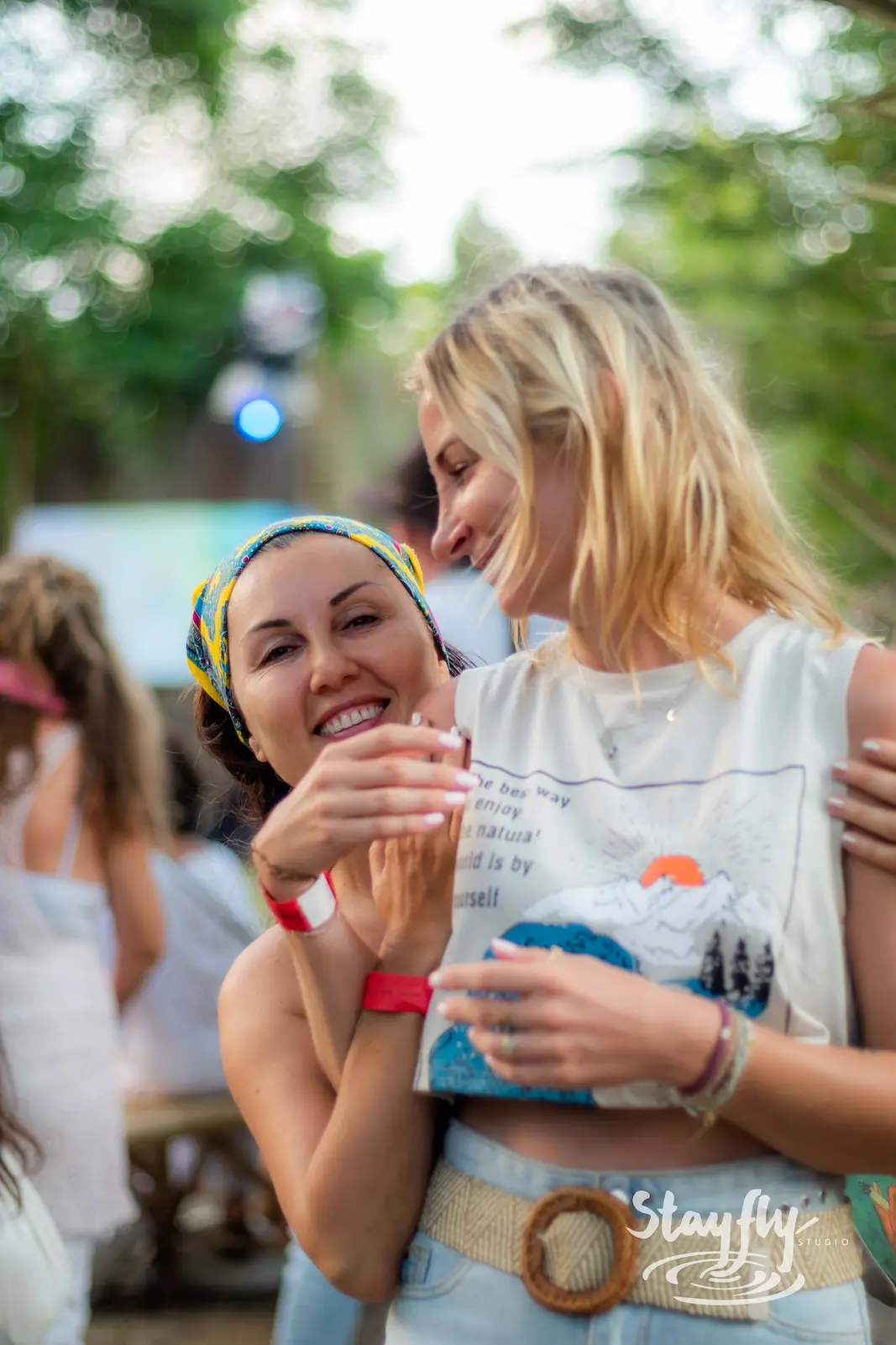 Two women laughing together at festival.