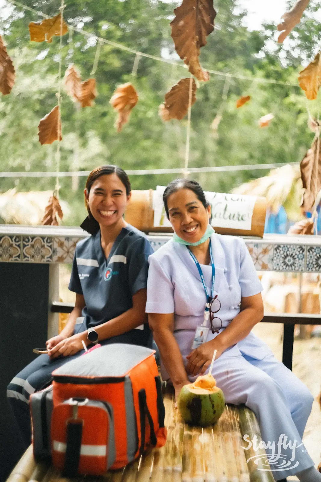 Two medics smiling with first aid kit and coconut.