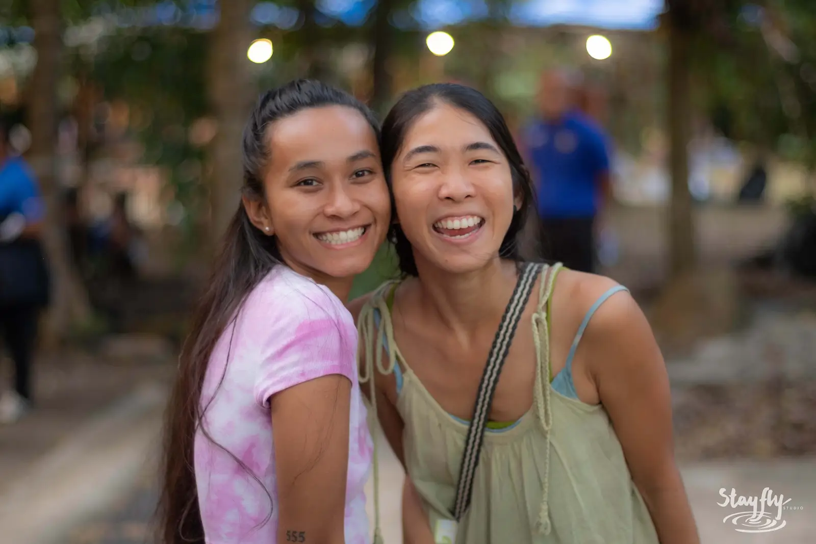Two women embracing and smiling for camera.