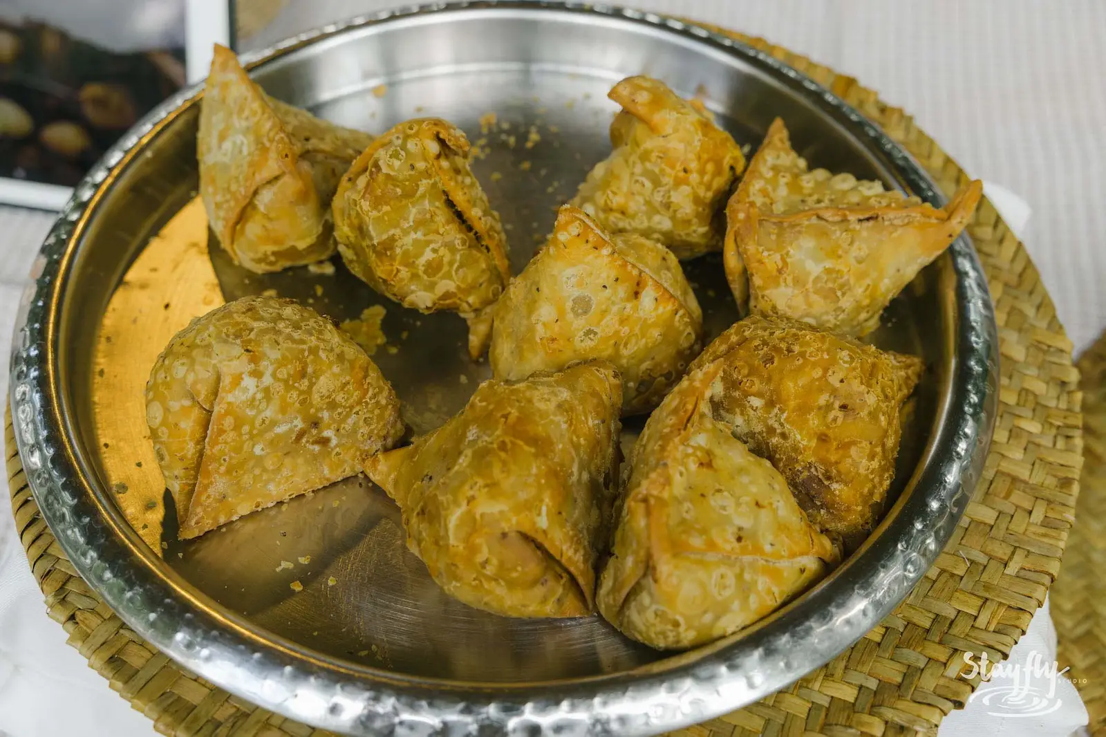 Fried samosas on a metal tray.
