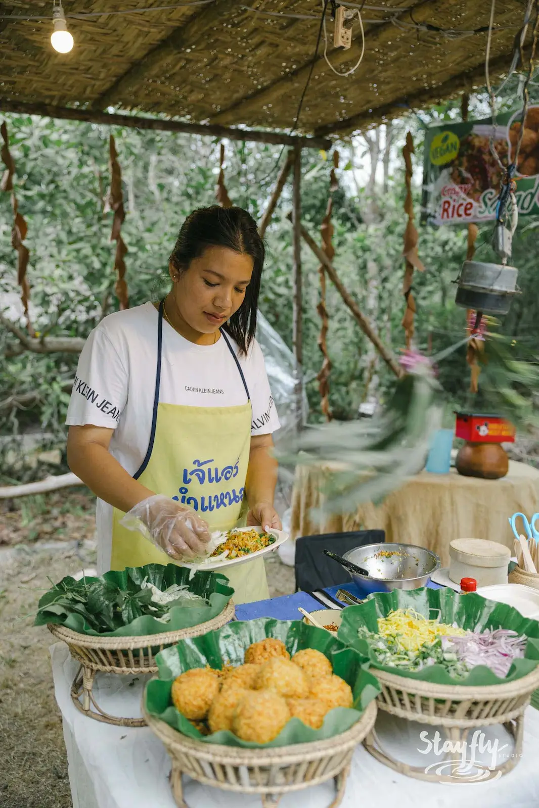 Woman serving rice balls at food stall.