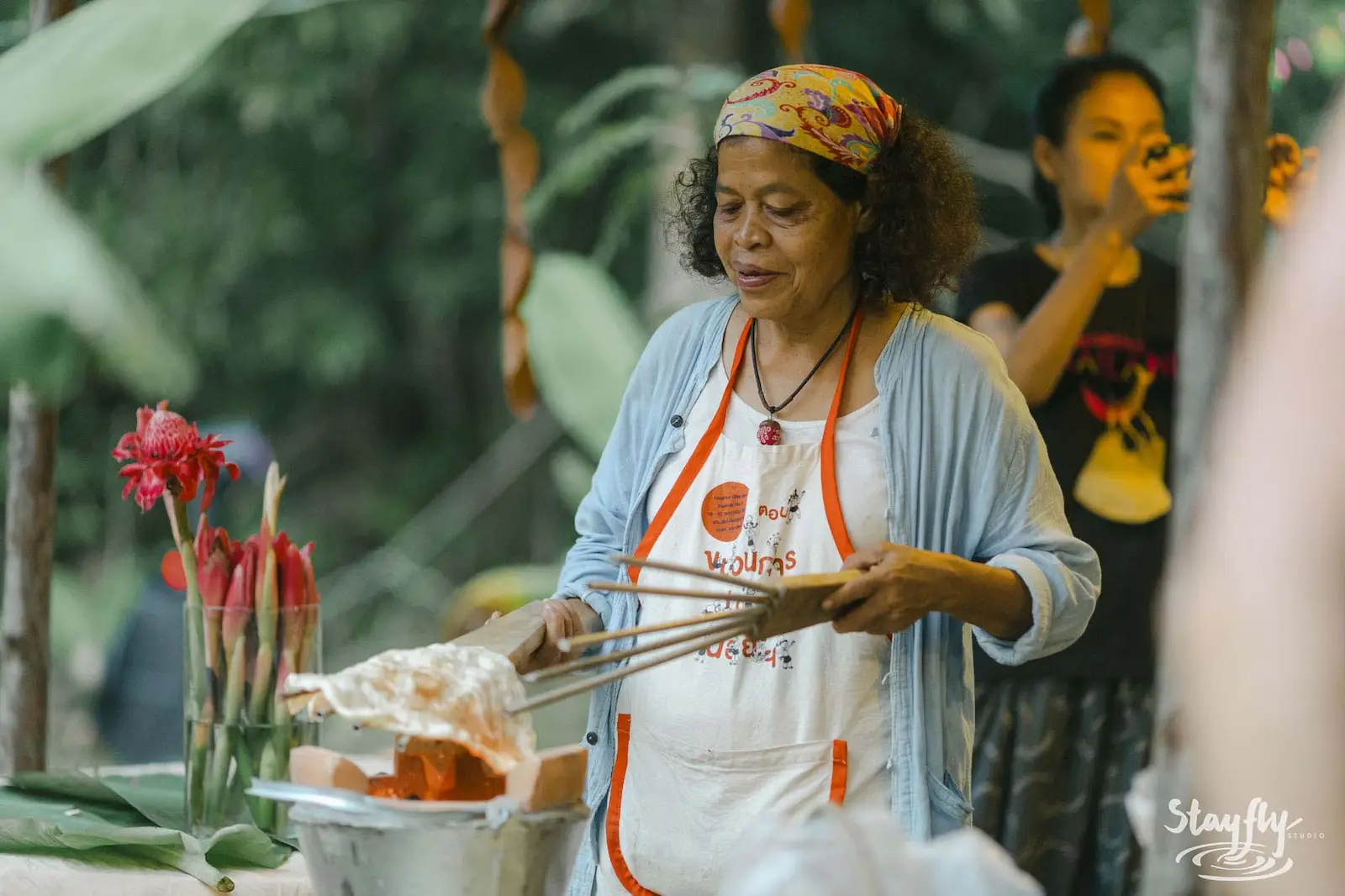 Woman cooking at outdoor kitchen stall.