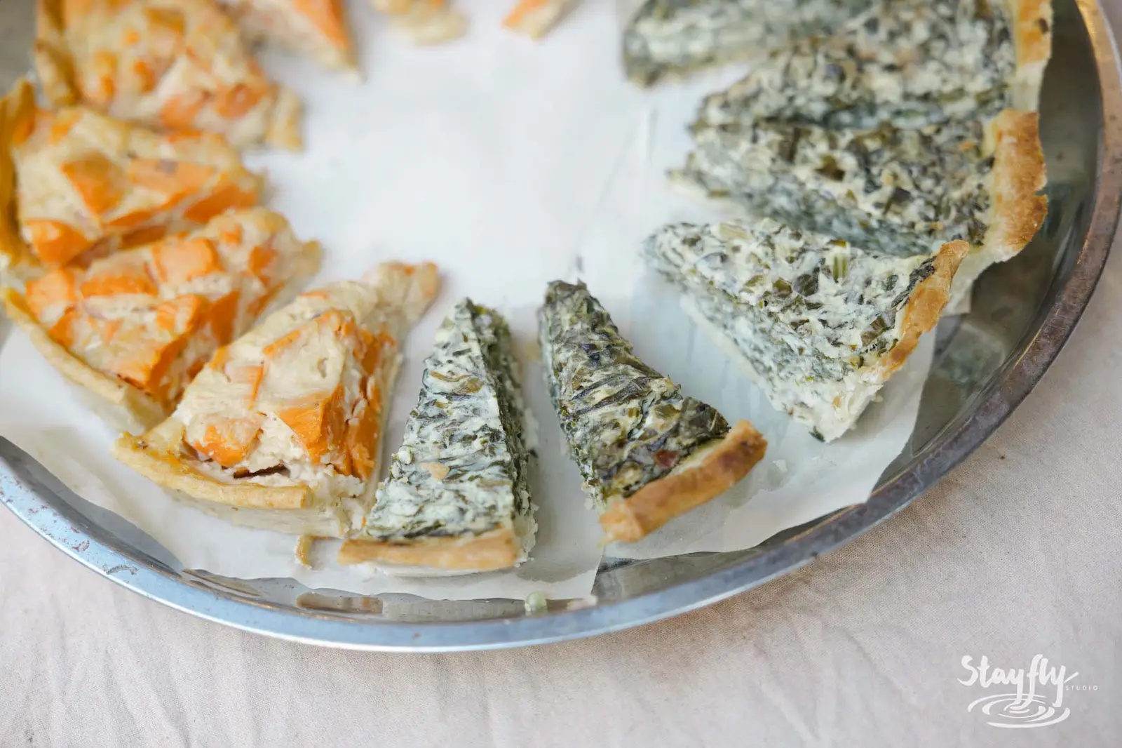 Quiche tart slices on serving tray.