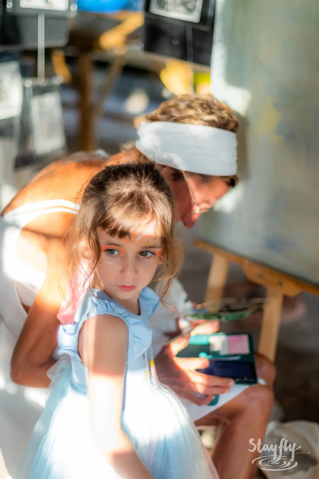 Child painting with adult at easel.