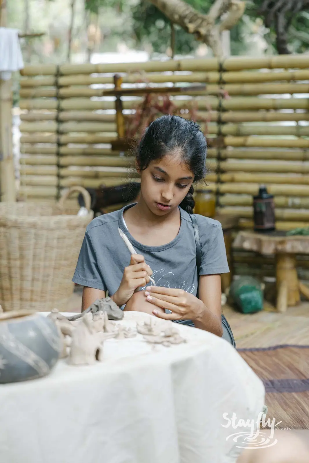 Girl painting small clay figure.