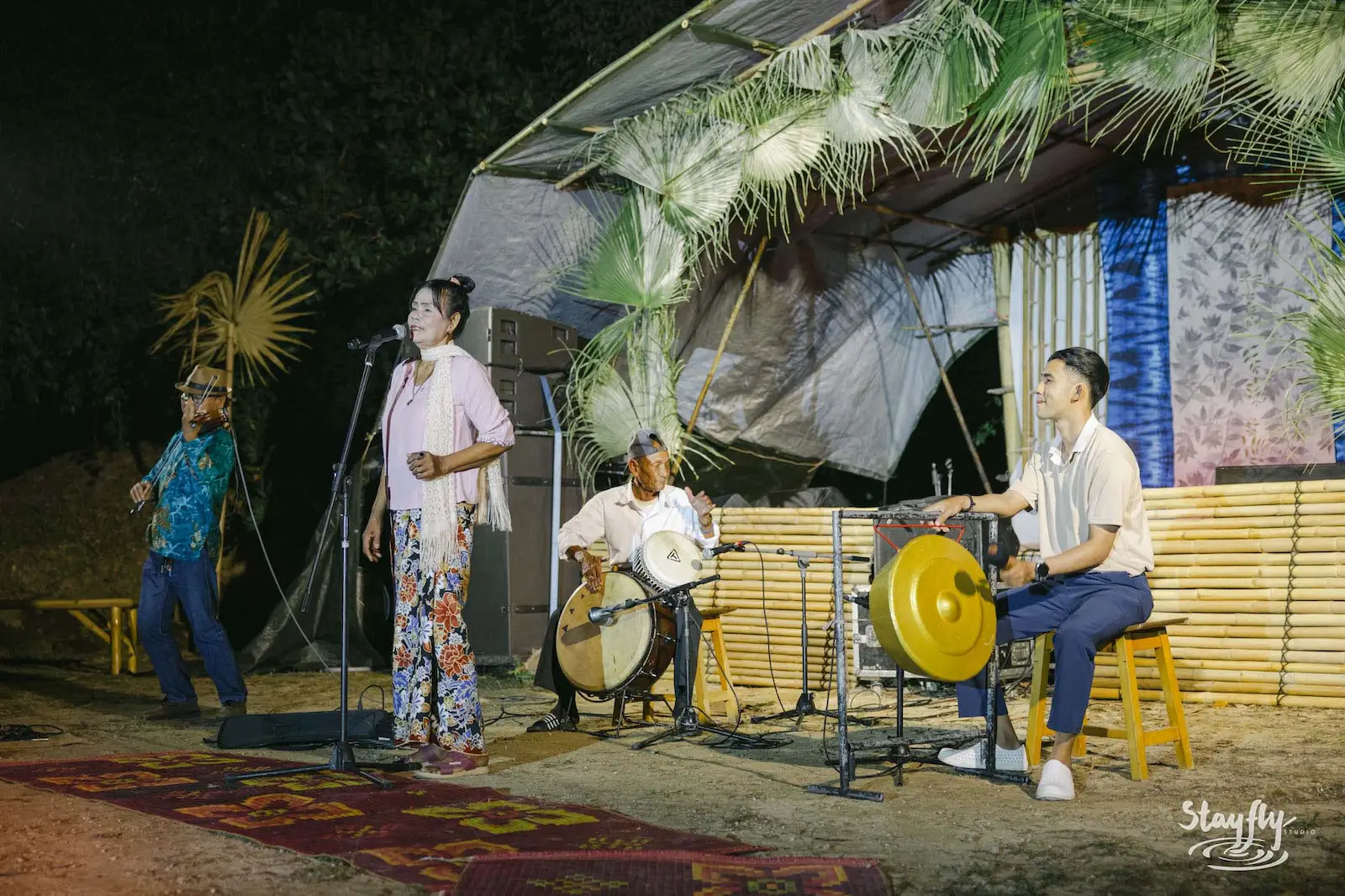 Thai band performing on stage at night.