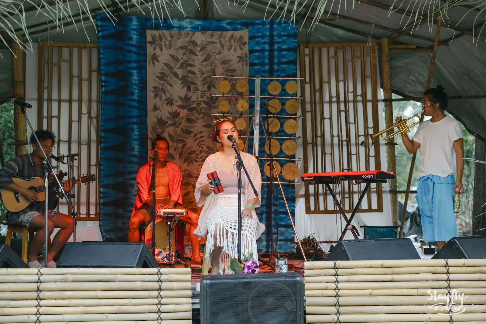 Singer and band performing on decorated stage.
