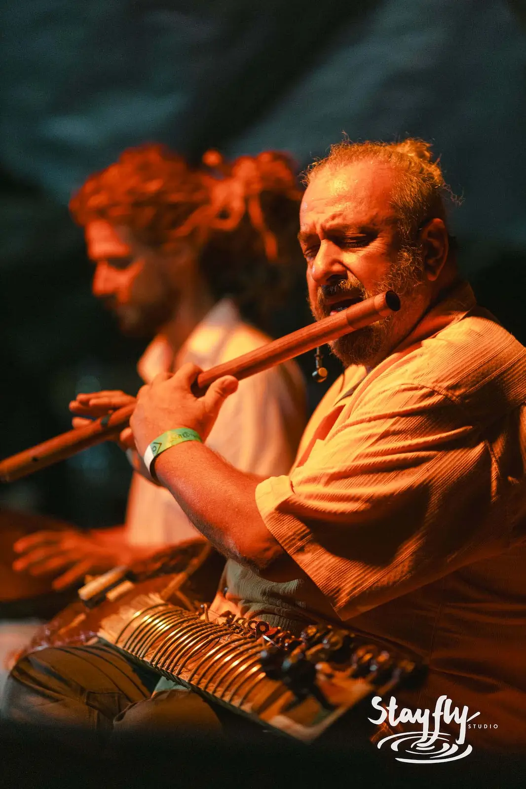 Two musicians playing flute and sarod onstage.