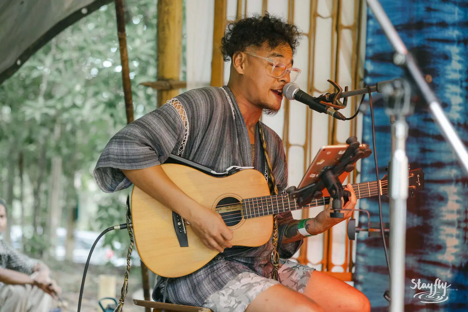 Young man singing and playing acoustic guitar.