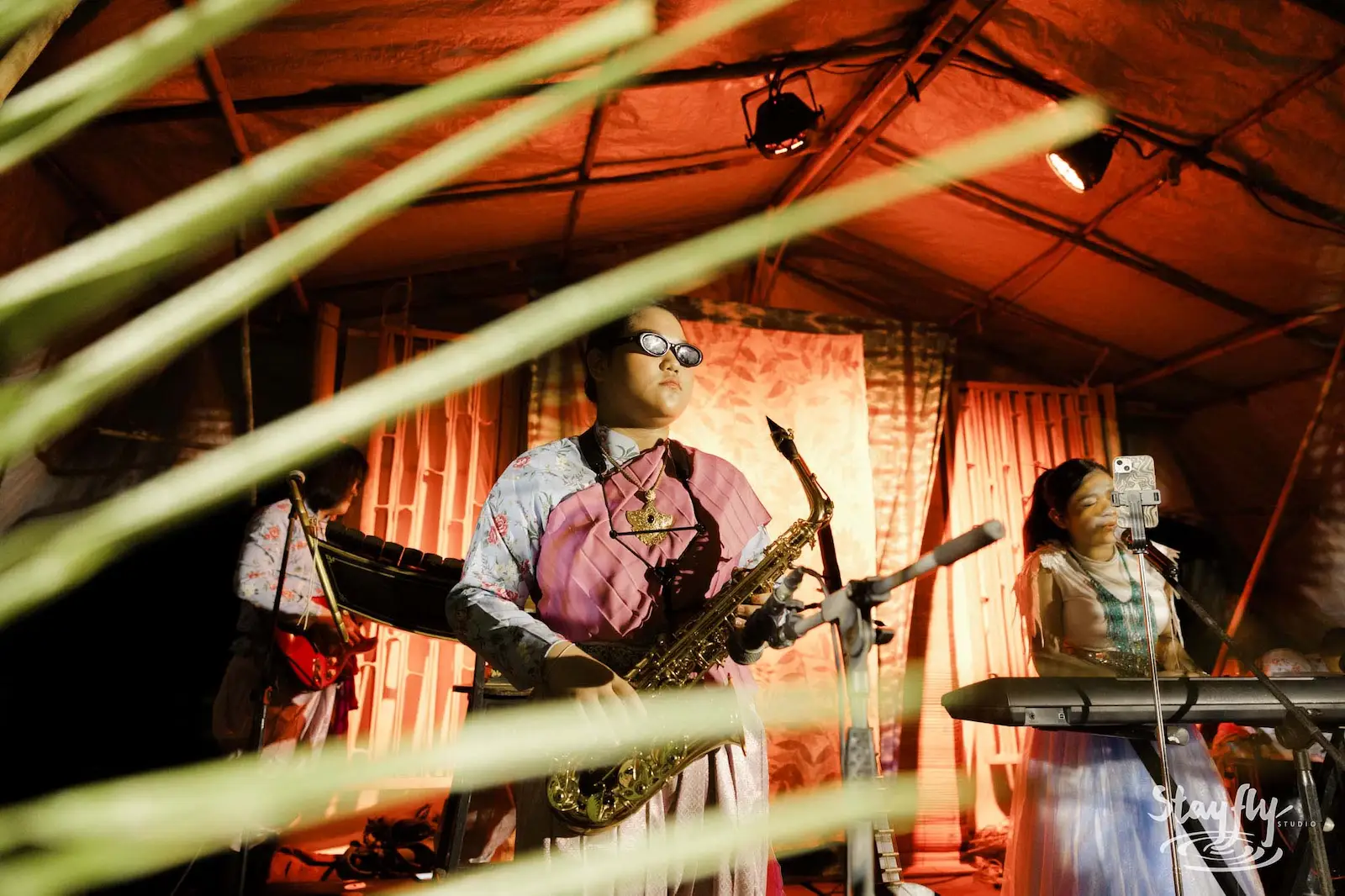 Saxophonist and singer performing on night stage.