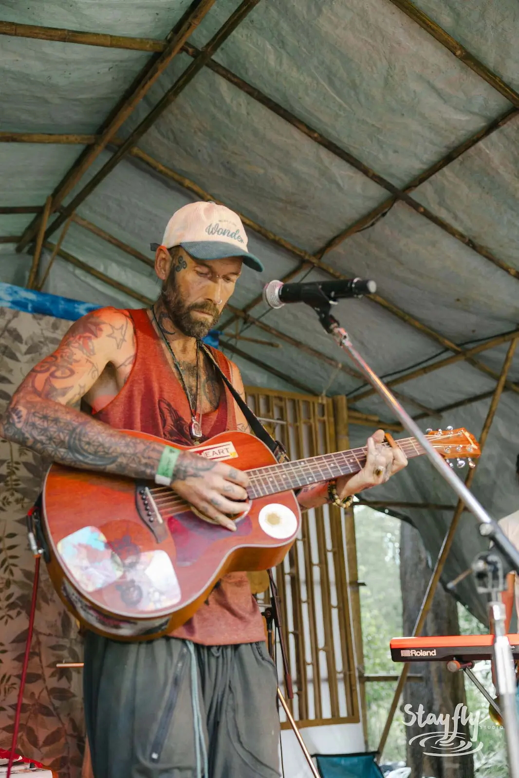 Man singing and playing acoustic guitar on stage.