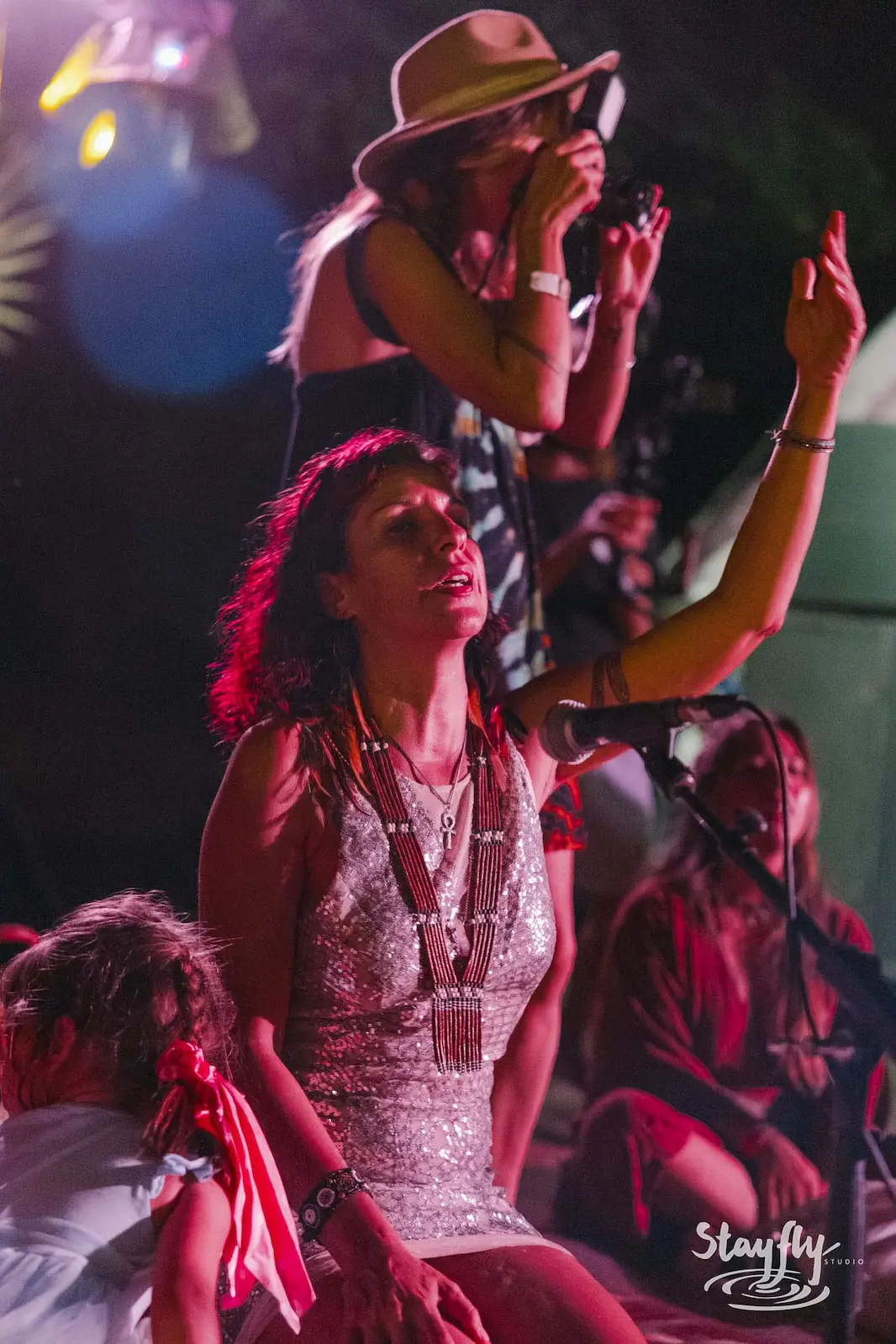 Female singer performing with hand raised.