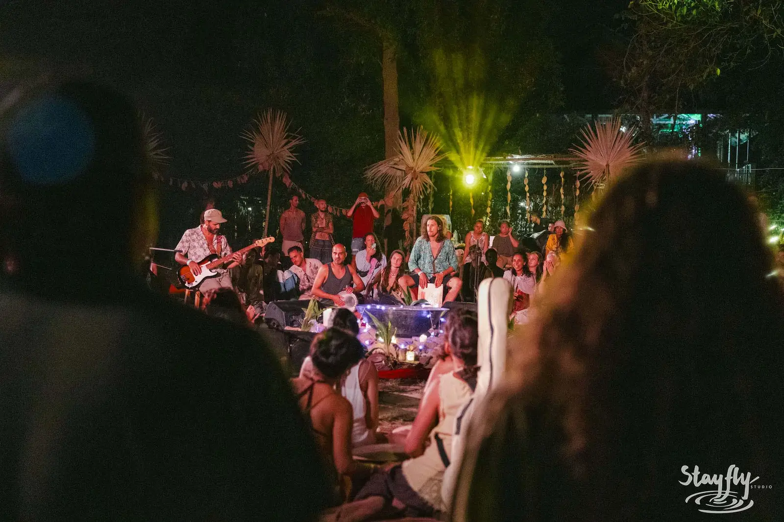 Band performing to seated crowd at night.