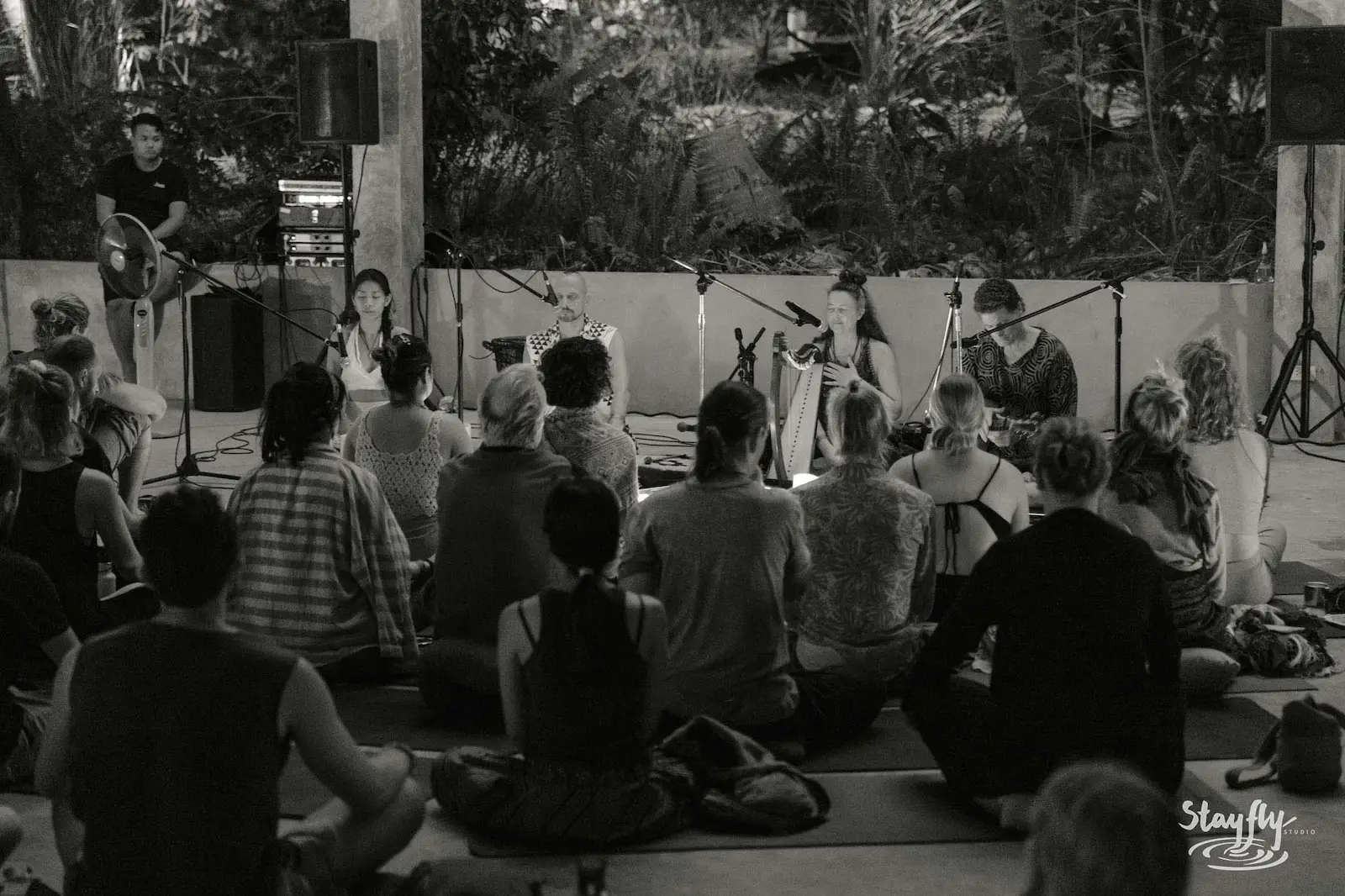 Black and white photo of band performing to seated audience.