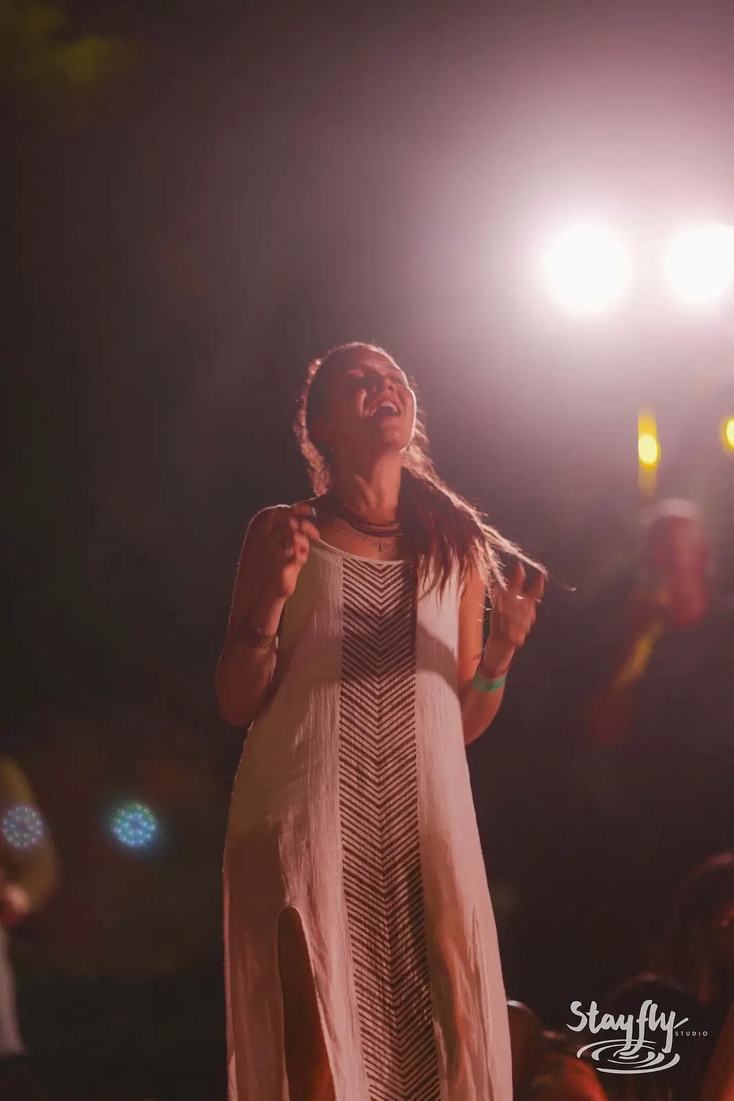 Woman singing passionately at night microphone.