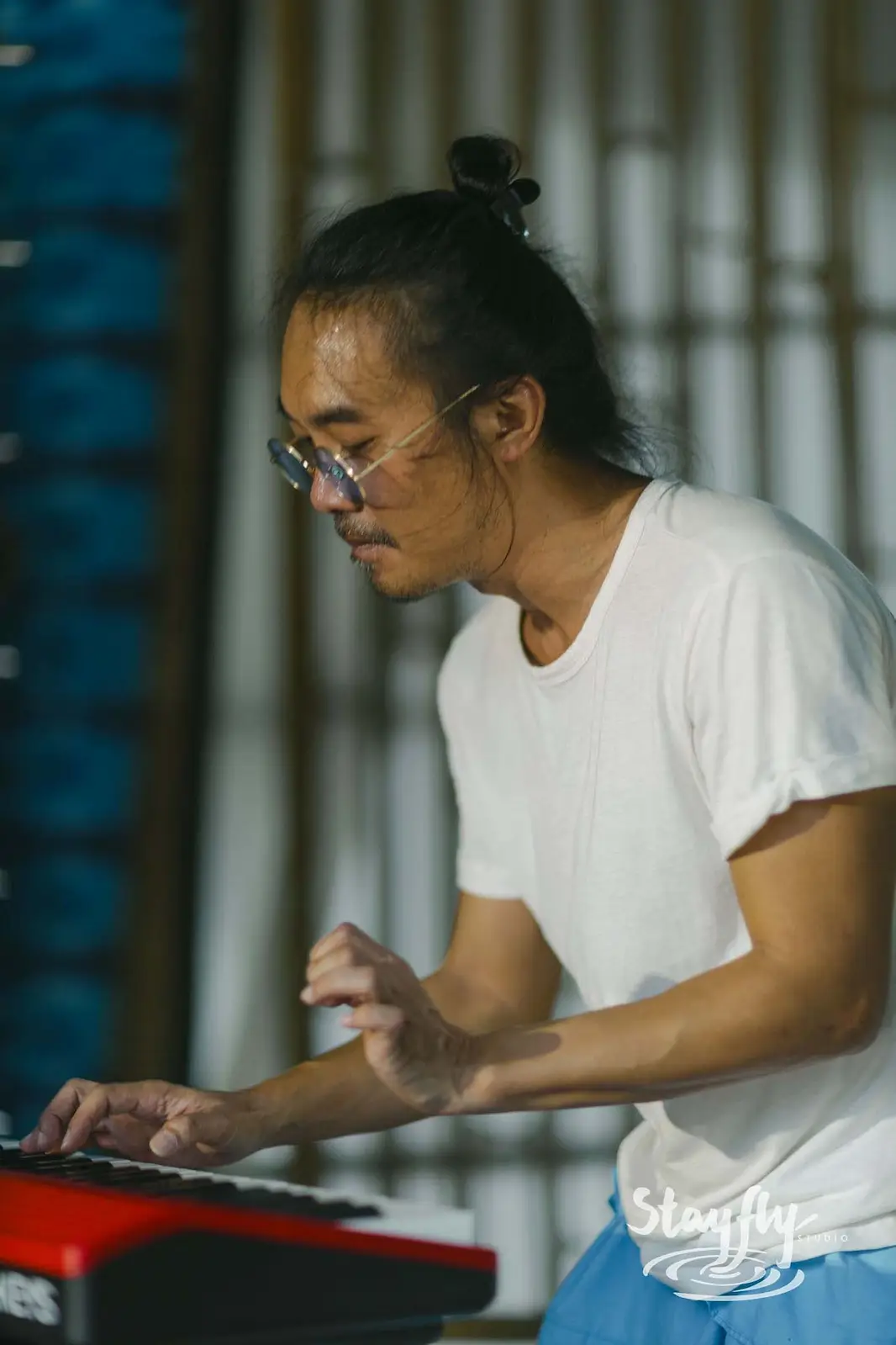 Man playing electric keyboard indoors.