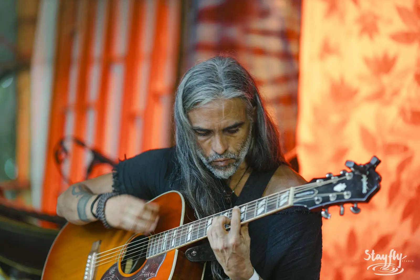 Guitarist playing on lit stage.