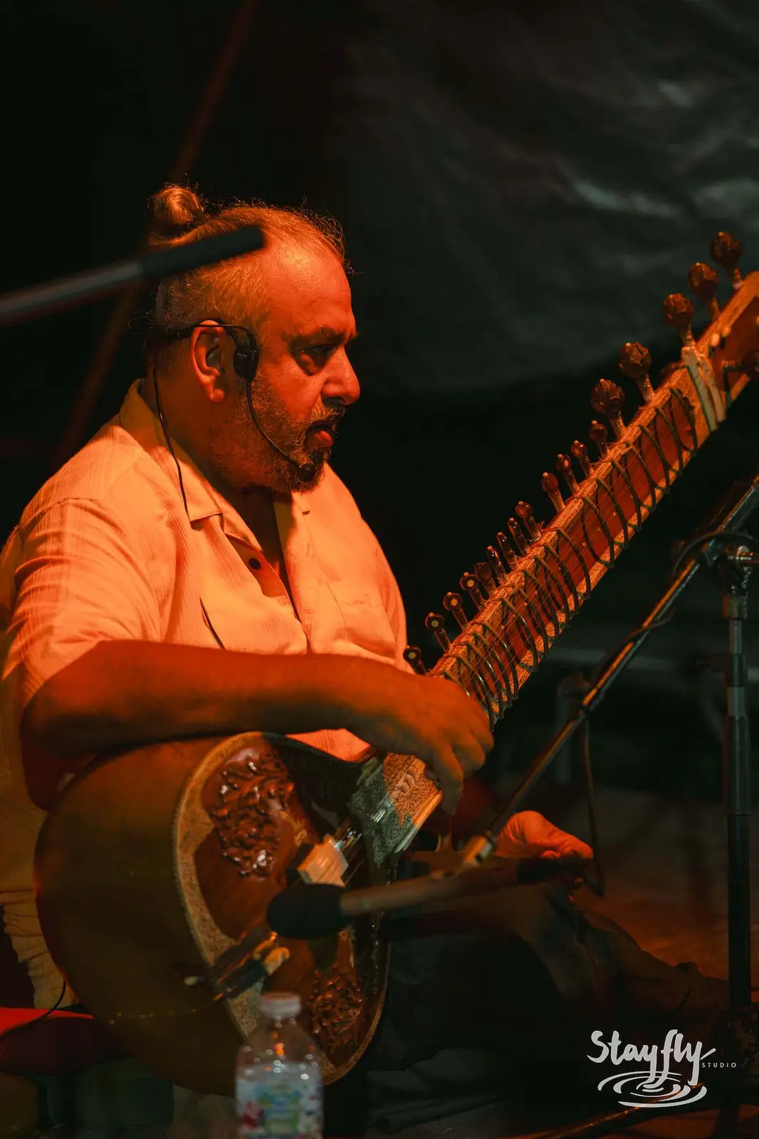 Musician playing stringed instrument on stage.
