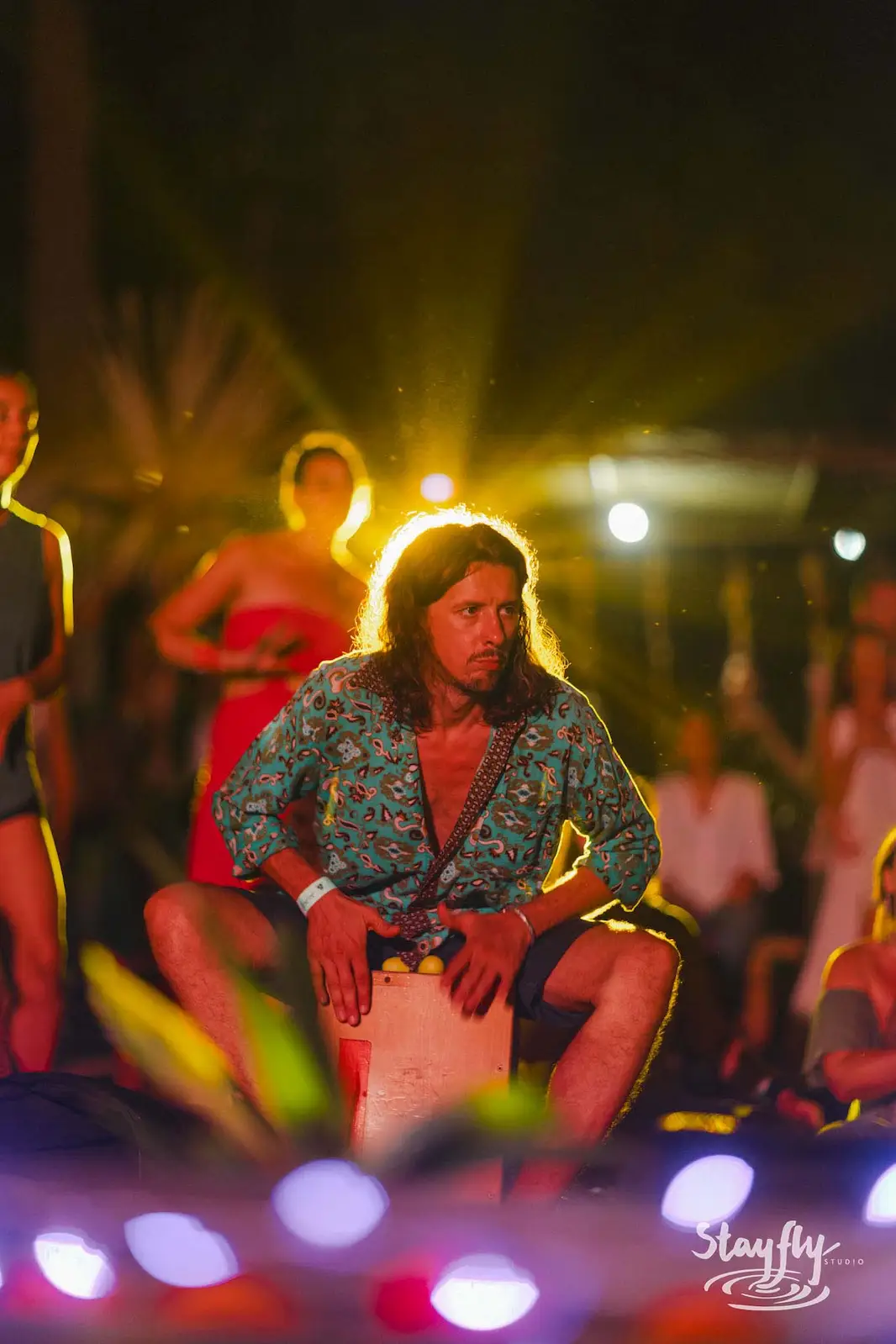Drummer playing conga at night stage.