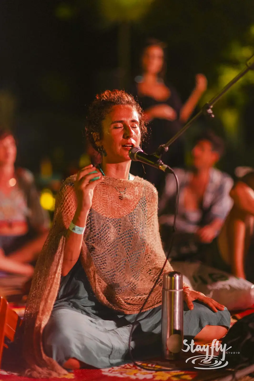 Vocalist singing on stage at night.