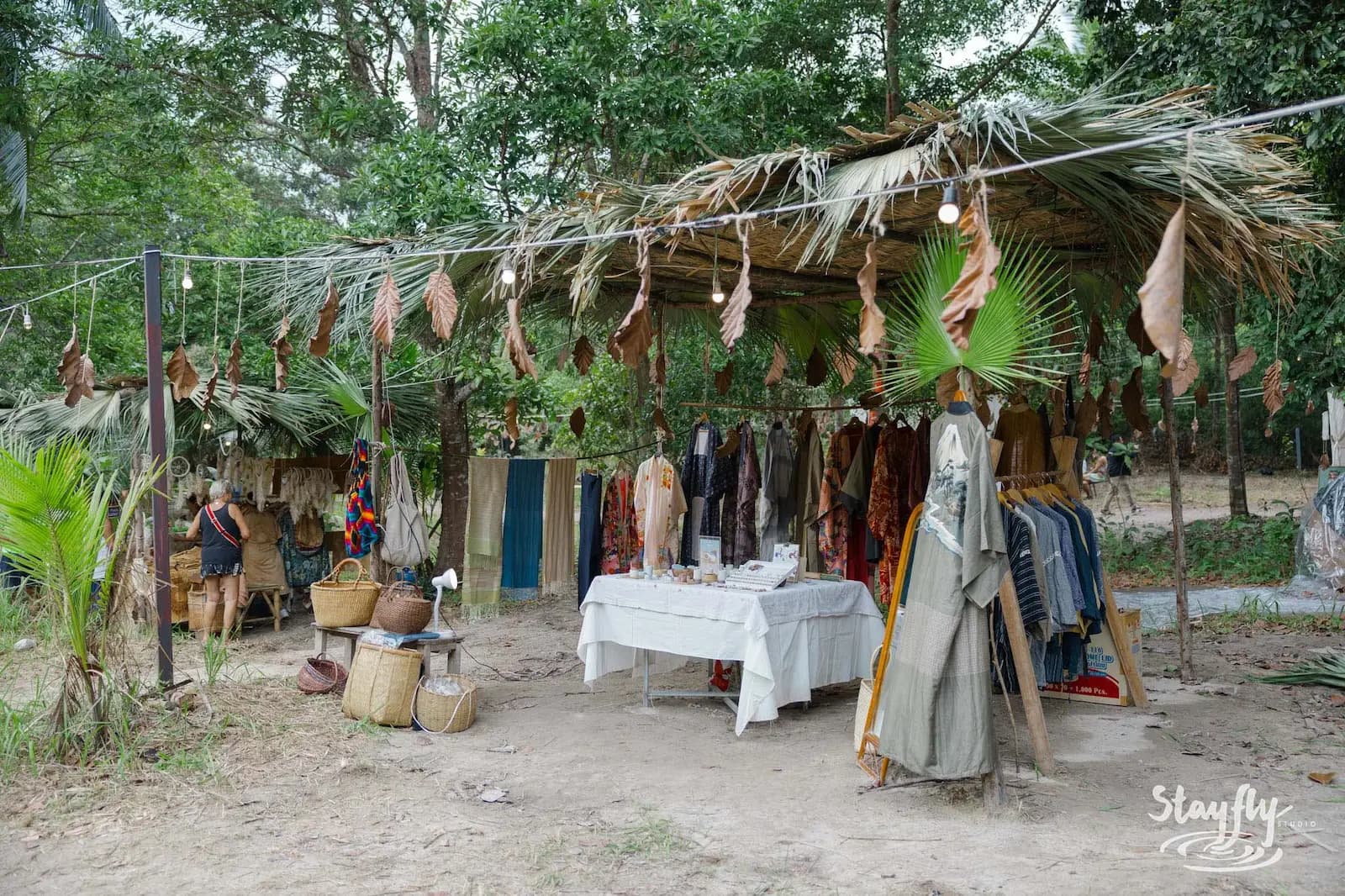Clothing market stall with mannequins and baskets.
