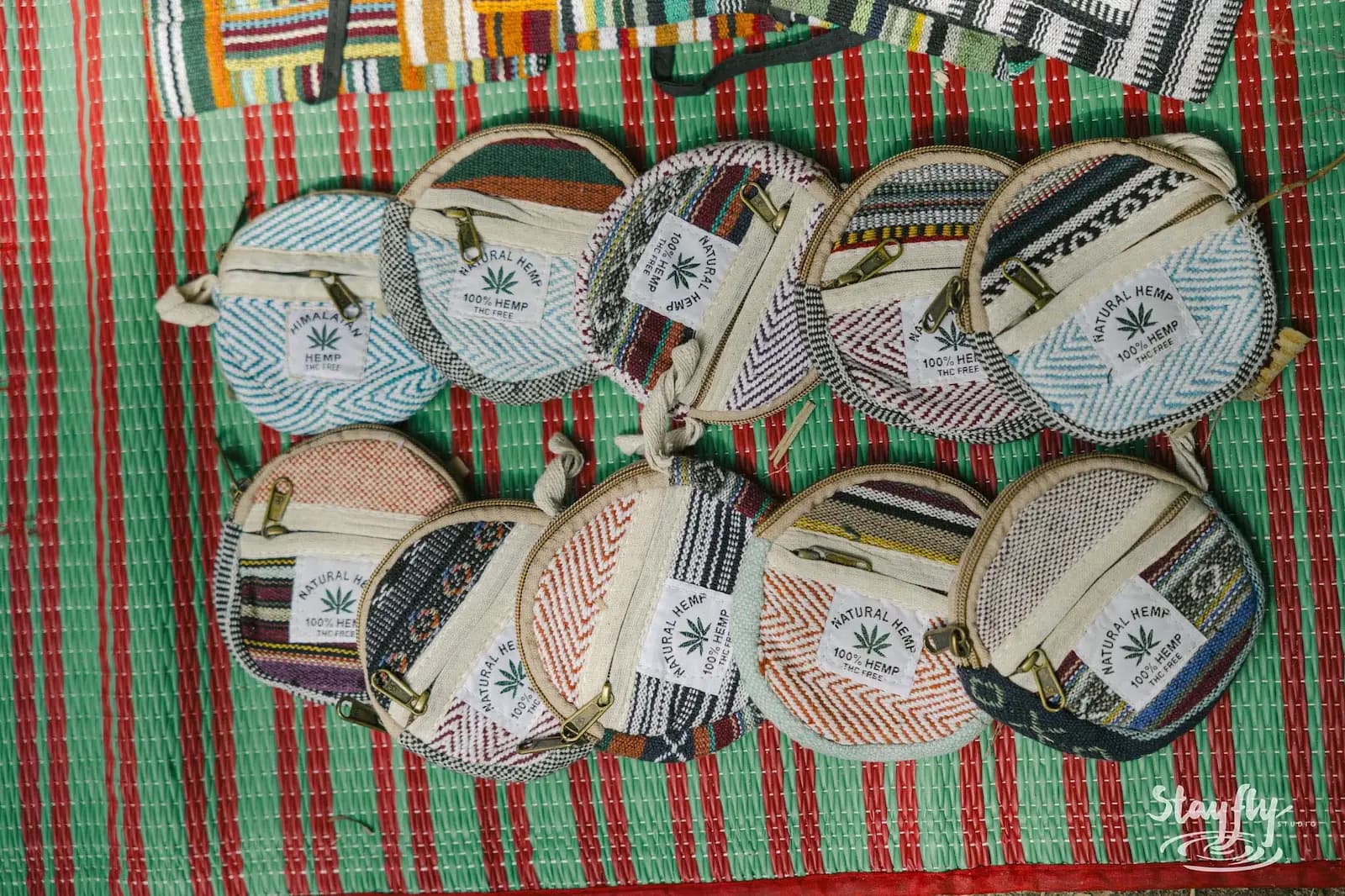 Closeup of round patterned coin pouches on woven mat.