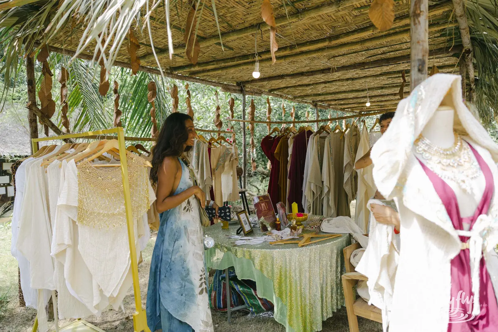 Woman shopping at dress and clothing market stall.