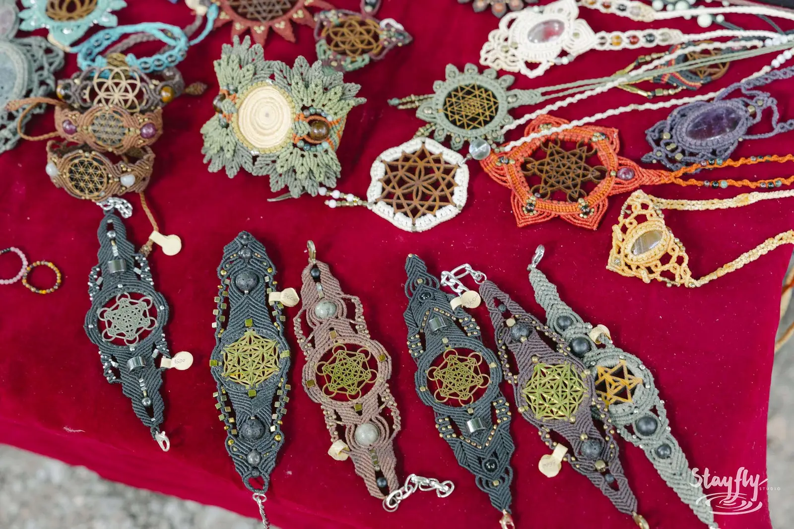 Handmade sacred-geometry bracelets on red velvet.