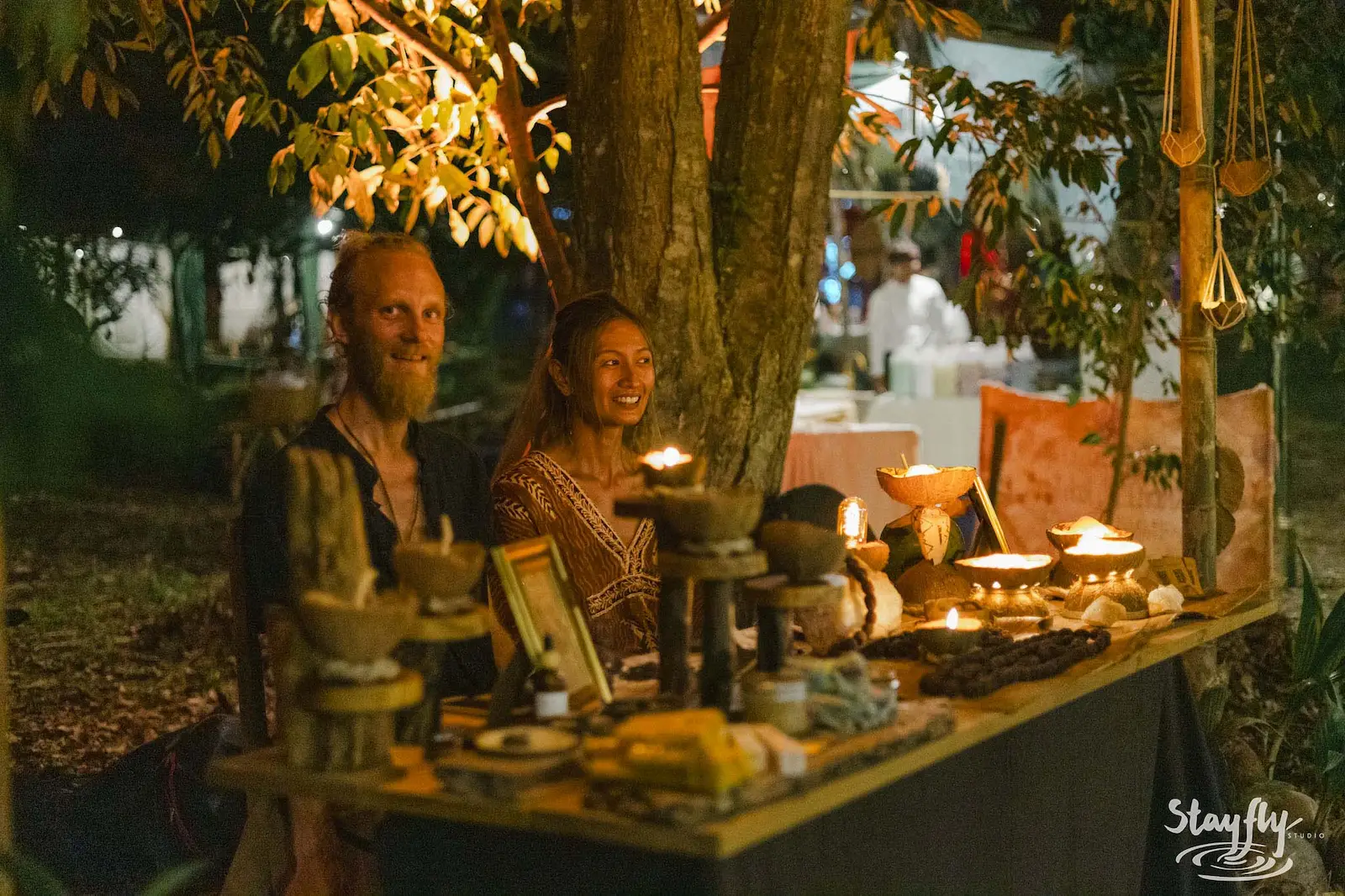 Couple at candlelit night market stall.