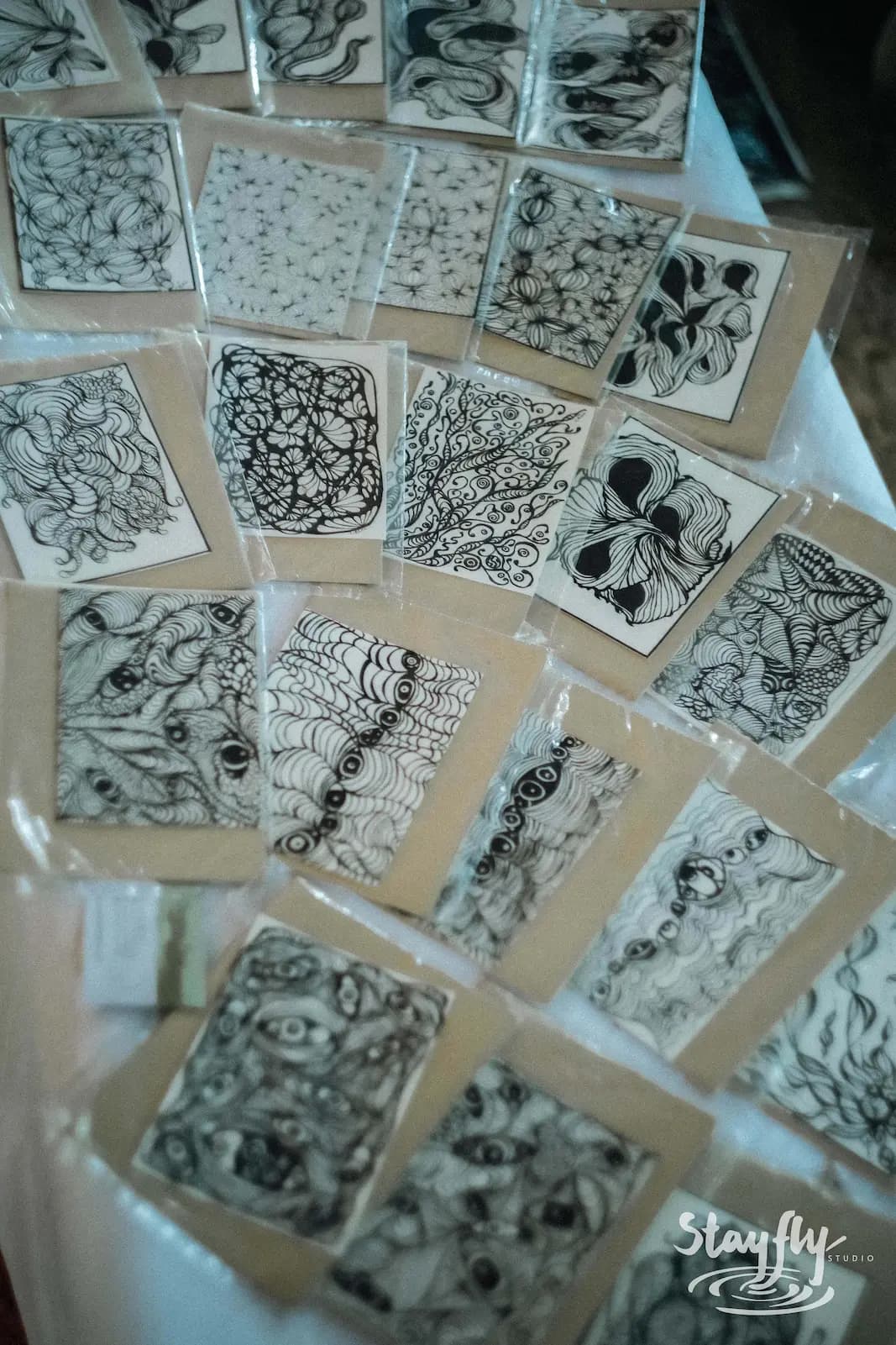Hand-drawn zentangle ink cards laid out for display.