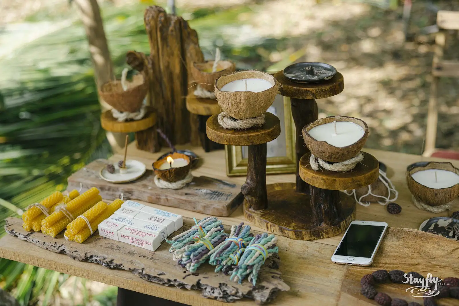 Coconut candle holders and corn on market table.