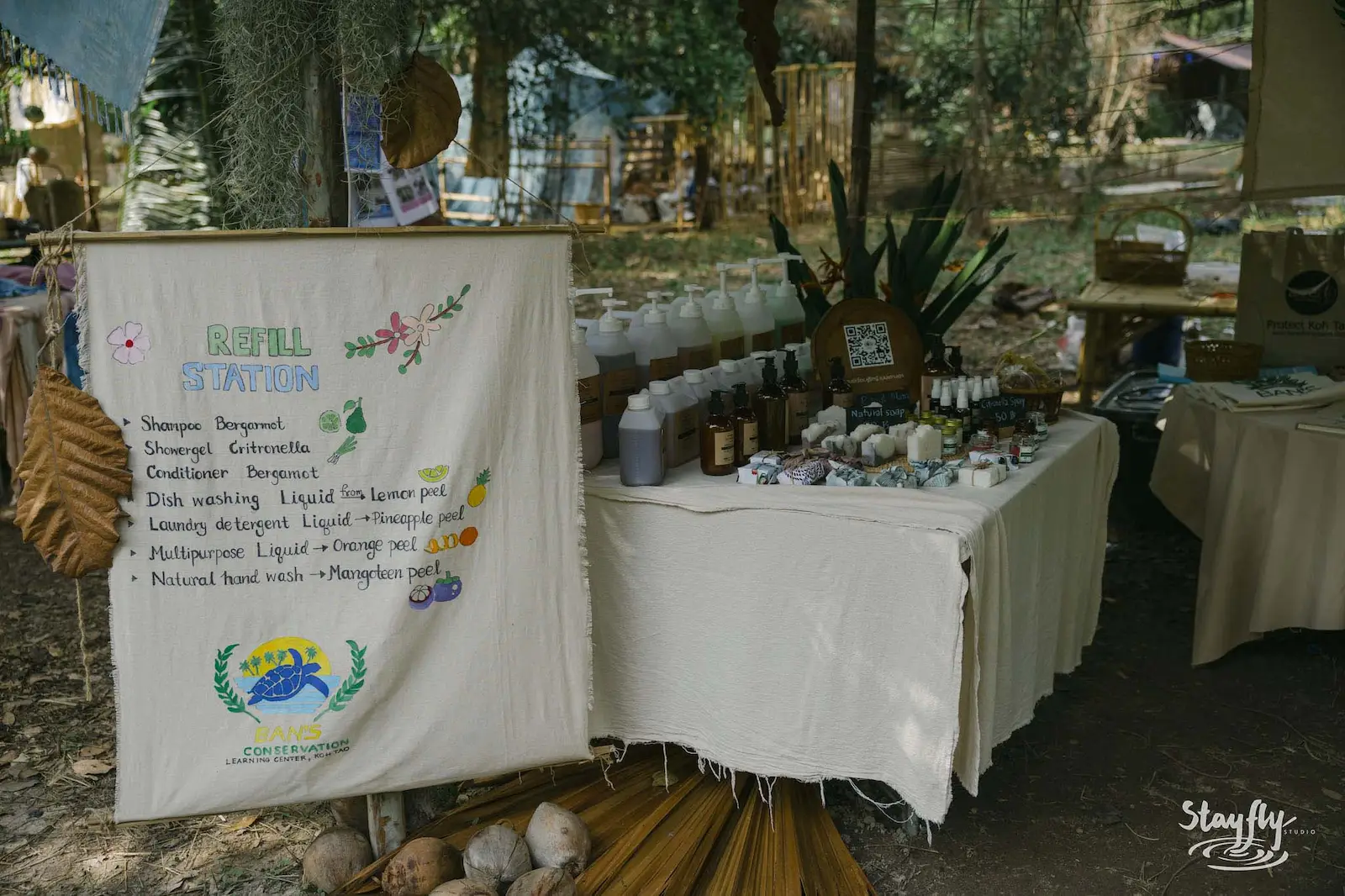 Refill station stall with bottles and instructions banner.