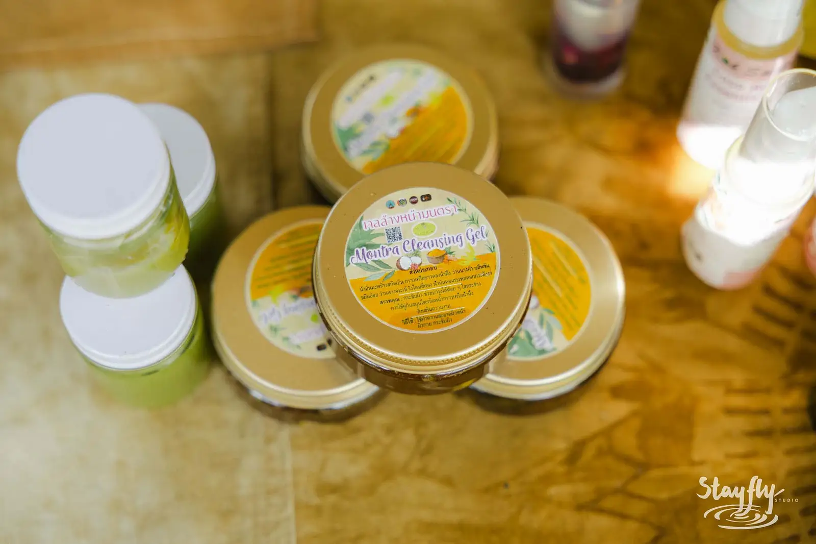 Handmade product jars displayed on wooden table.