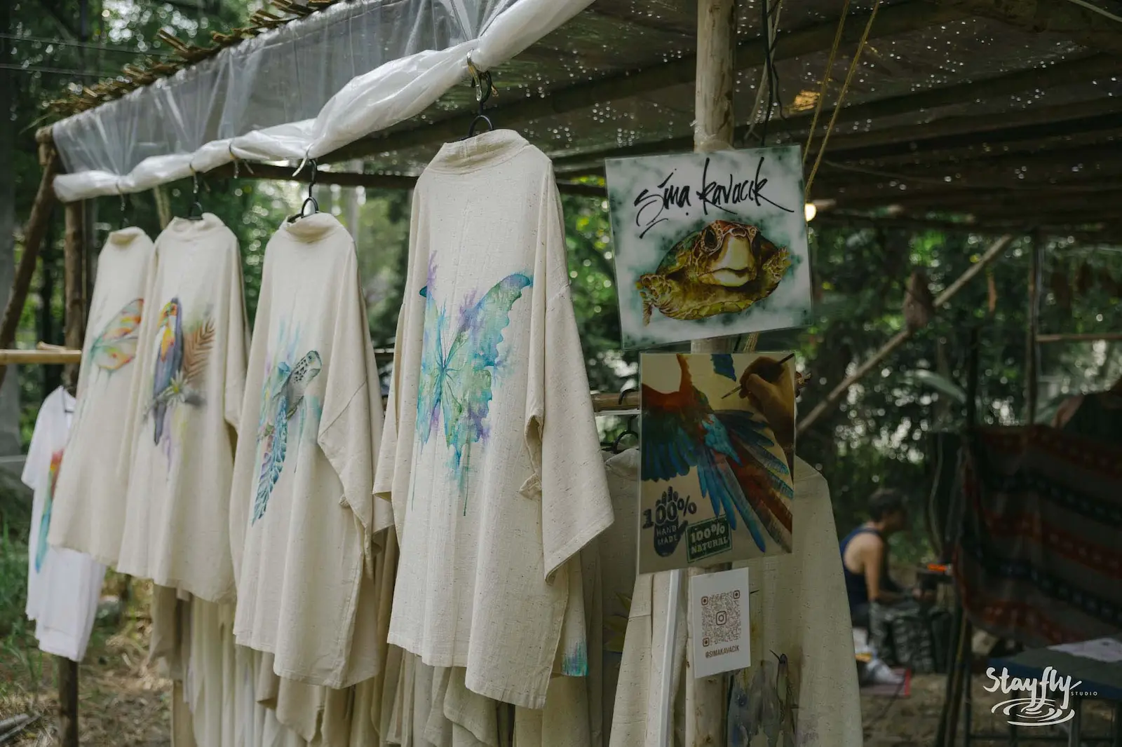 Hand-painted shirts hanging at a market stall.