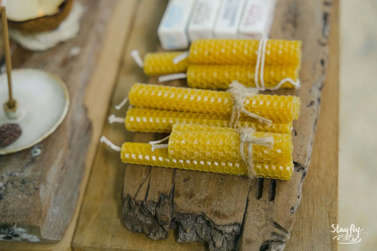 Handmade beeswax candles on wooden stall.