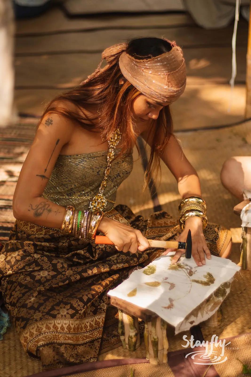 Woman eco-printing leaves onto fabric.