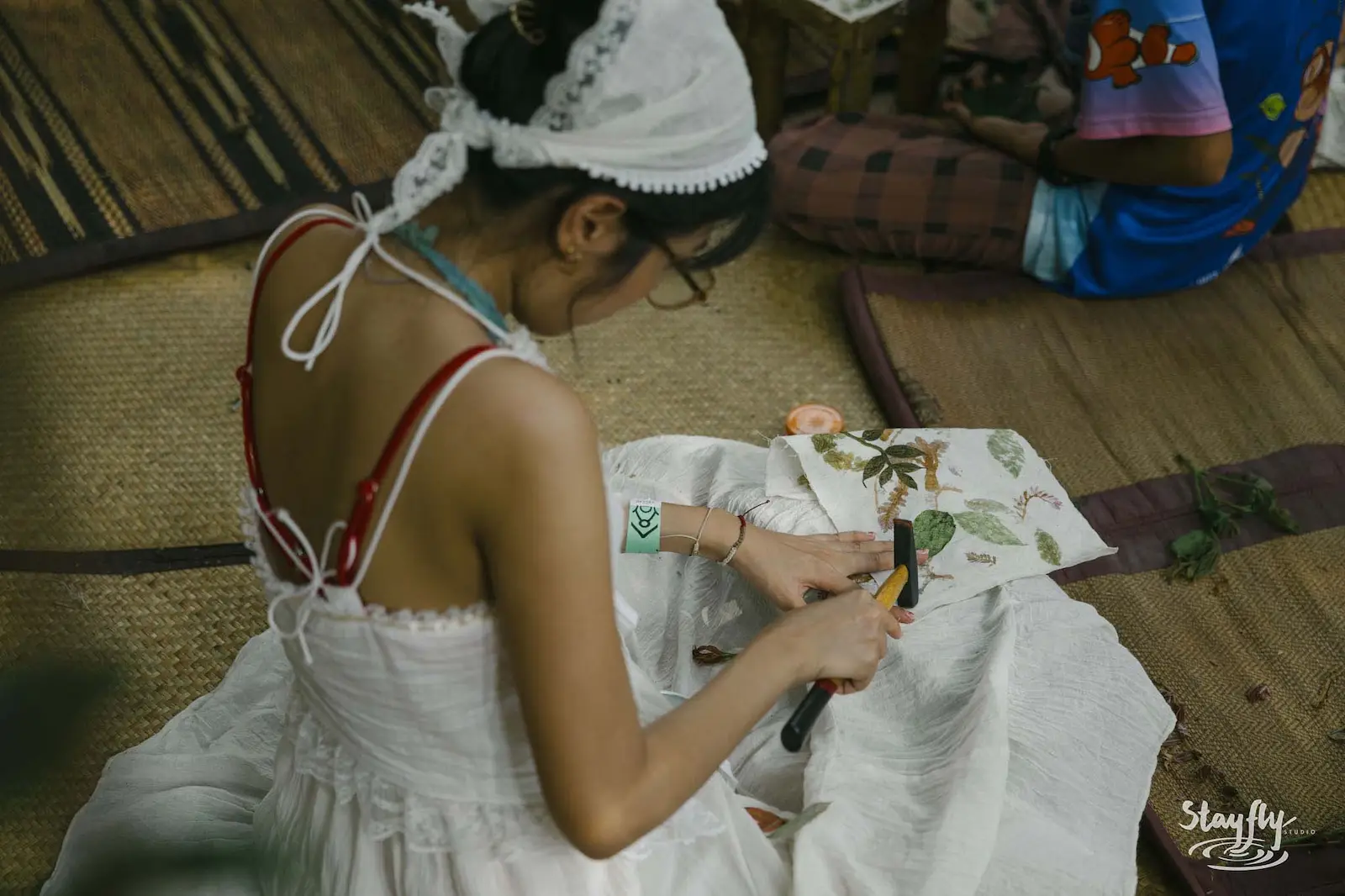 Woman in traditional dress doing embroidery.