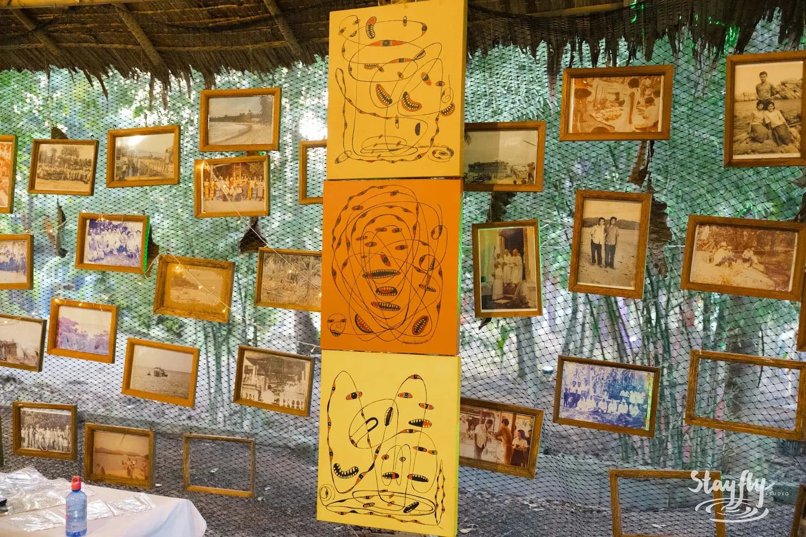 Vintage photo wall beside abstract painted panels.
