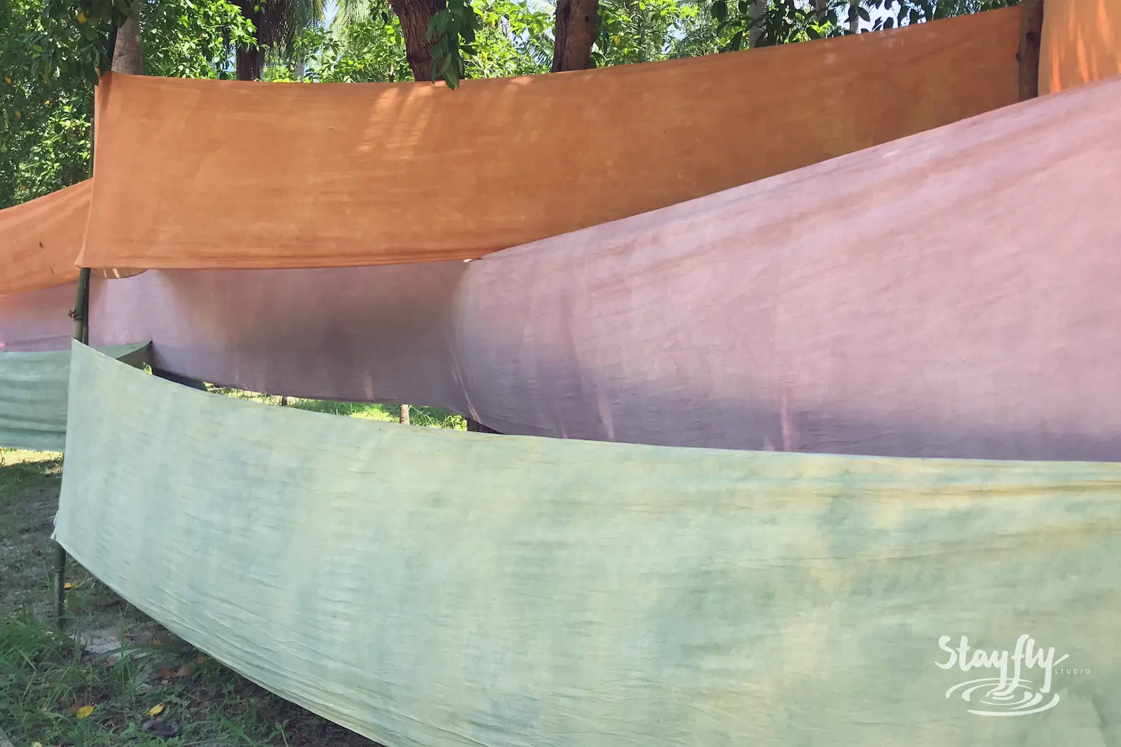 Draped orange pink and green fabric banners.