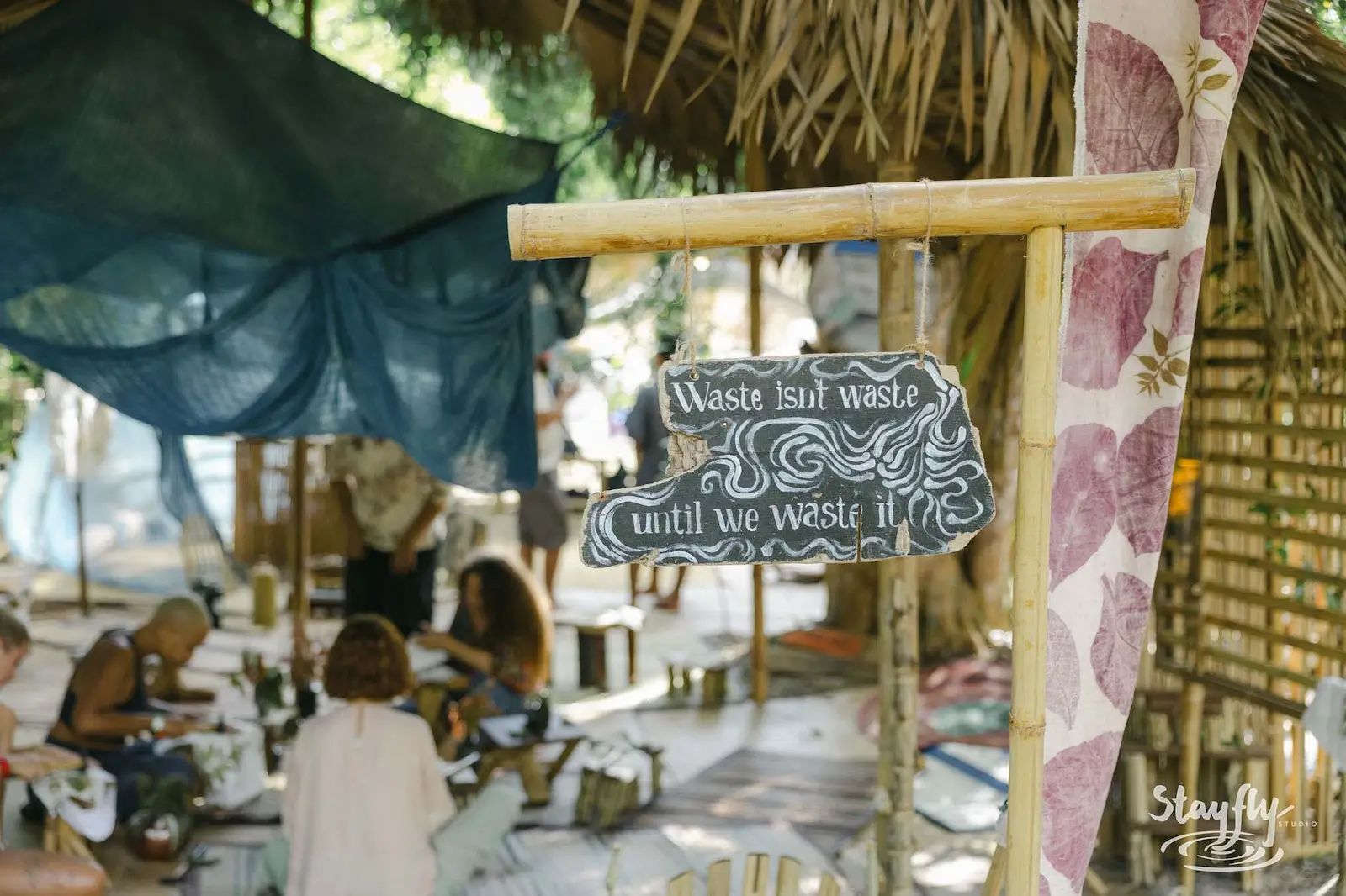 Hanging sign reads waste isn't waste until wasted.